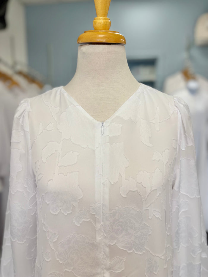 Long white dress with floral appliques and zipper front.