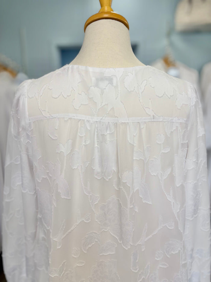 Back of long white dress with floral appliques.