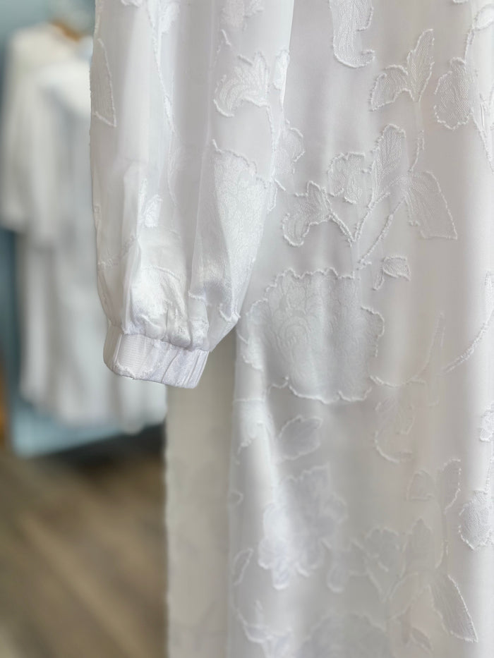 Long white dress with floral appliques.