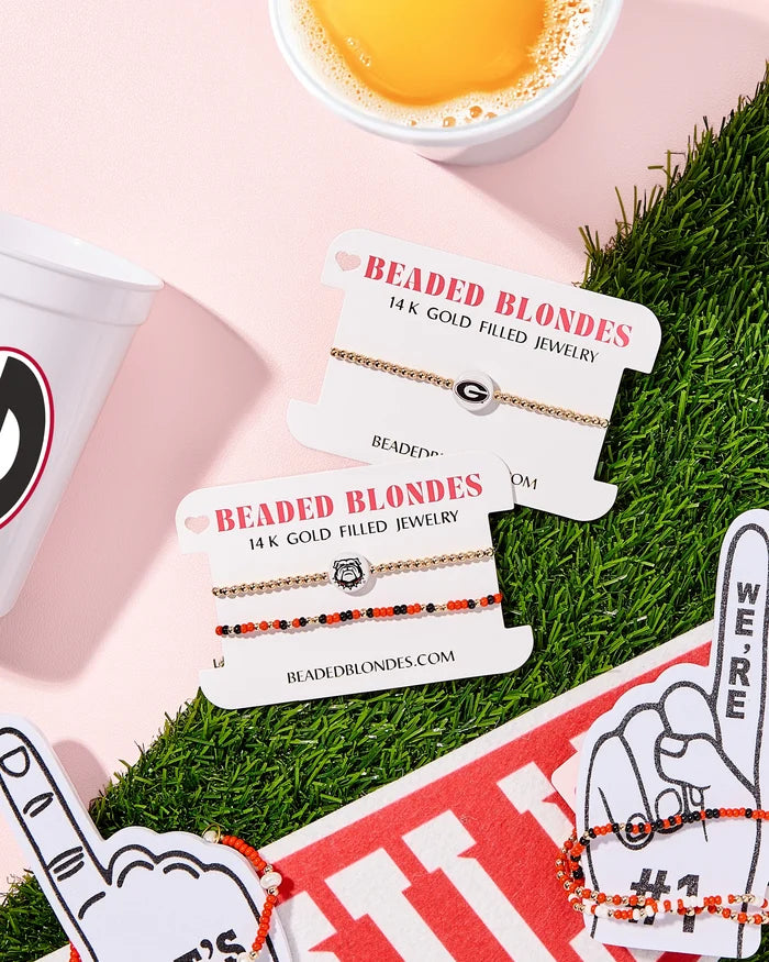 Beaded Blondes jewelry cards with bracelets on a grassy stadium