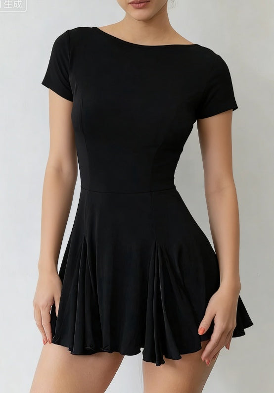 Model wearing an elegant black dress with boat neckline and defined waist on a clean studio background.
