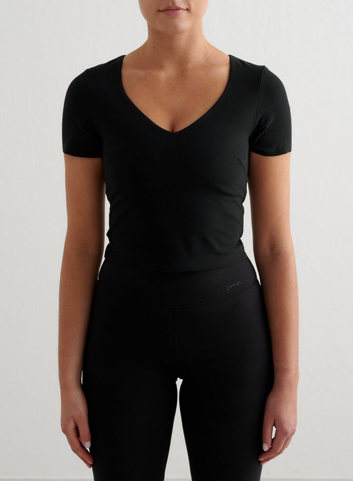 Musta lyhythihainen Sense Short Sleeve Bralette V-kaula-aukolla ja pehmeällä second skin -kankaalla merkiltä aim'n.