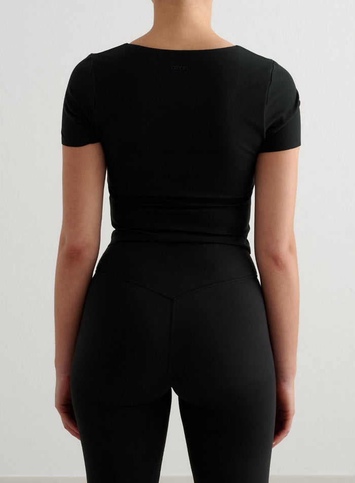 Musta Sense Short Sleeve Bralette second skin -tuntumalla, kuvattuna takaapäin pienellä aim'n-logolla.