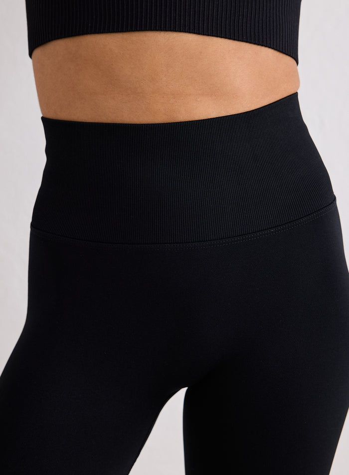 Lähikuva mustien Shape Seamless 7/8 Tights -trikoiden korkeasta vyötärönauhasta merkiltä aim'n [XS-170cm]