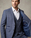 Man wearing a blue checkered suit with a white shirt against a neutral background