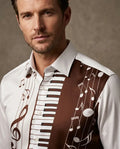 A close-up of a man wearing a white button-up shirt with a brown and white musical-themed print featuring piano keys, musical notes, and a treble clef.
