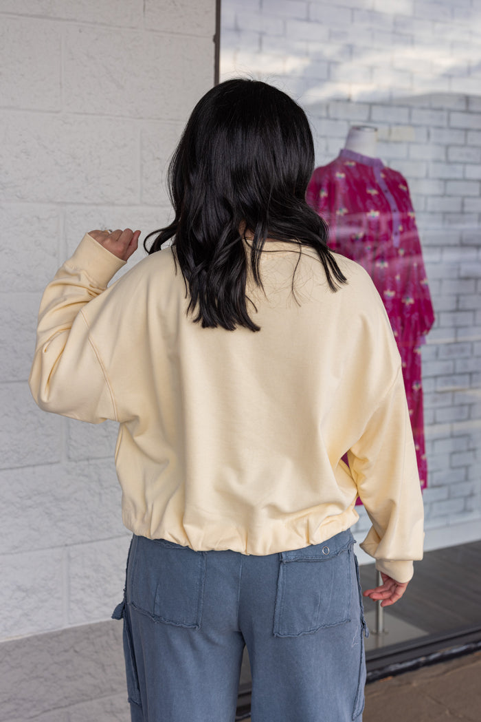 Women's butter pale yellow terry knit long sleeve pullover top with bubble hem by Wishlist showing up close back view