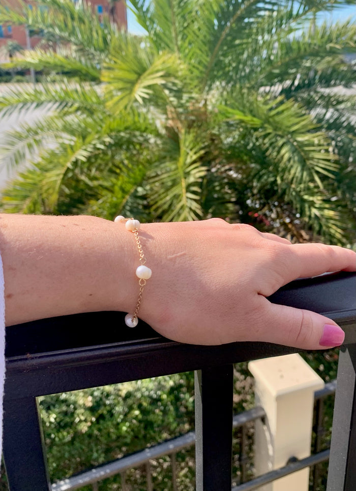 Scattered pearls on gold chain bracelet adjustable on model