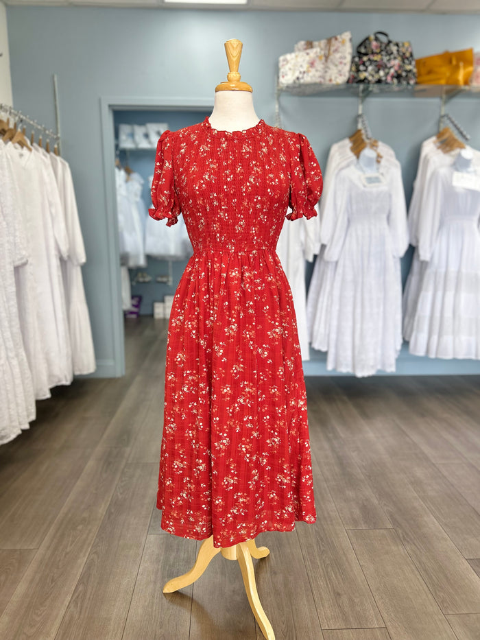 Red midi dress with floral pattern and smocked bodice.