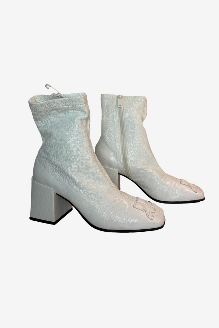 Pair of light gray ankle boots with block heels on a white background