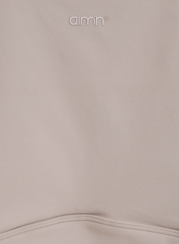 Lähikuva Dark Clay Sense Sports Bra -urheiluliivien pehmeästä harjatusta kankaasta ja painetusta aim'n-logosta.