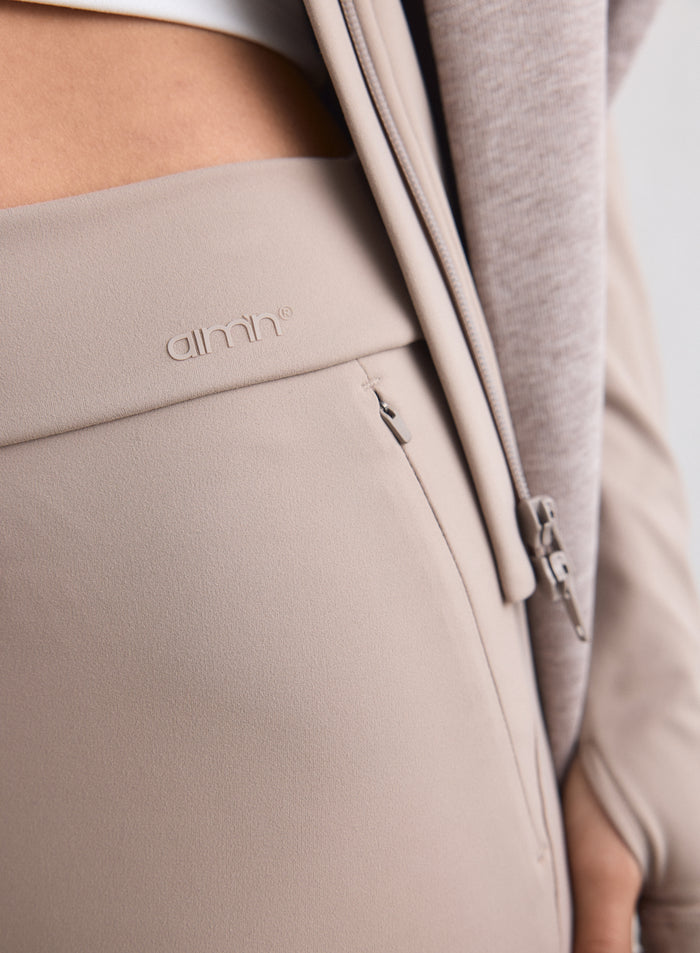 Lähikuva aim'n Dark Clay Sense Tall Pants -housuista kohokuvioidulla logolla ja vetoketjutaskulla. [M-170cm]