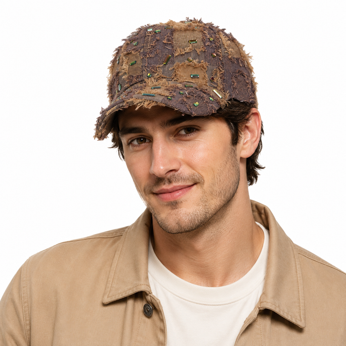 Close view of distressed baseball cap showing woven construction, fringed detailing and shiny diamond accents in retro style.