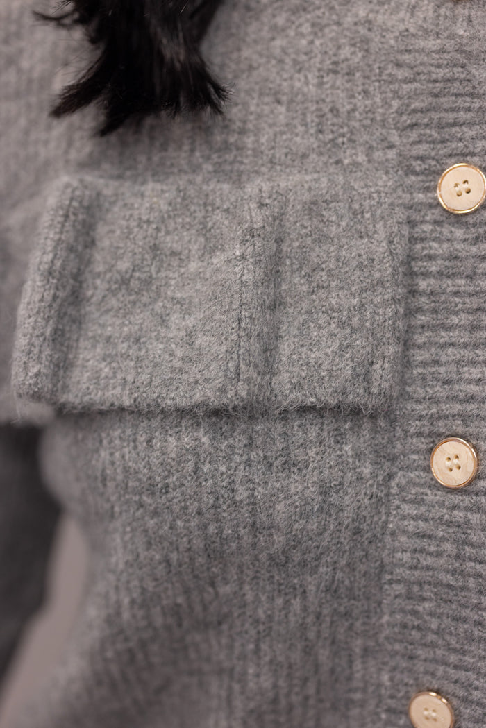 Women's grey knit sweater with a ruffle across the front chest and back shoulders by Wishlist showing button details