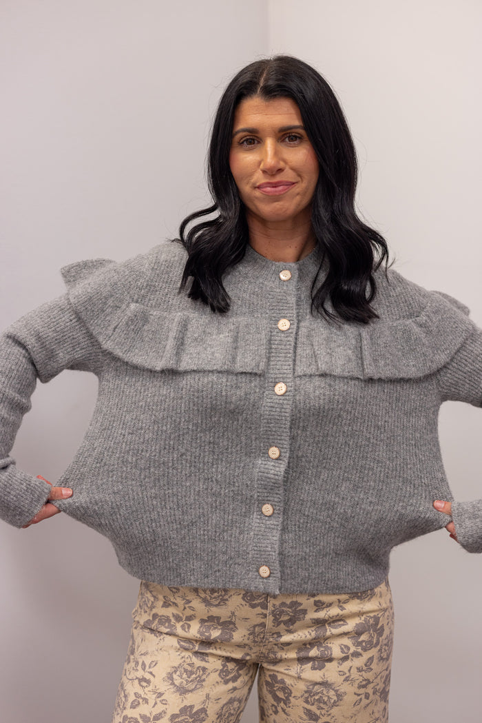 Women's grey knit sweater with a ruffle across the front chest and back shoulders by Wishlist showing true to size fit