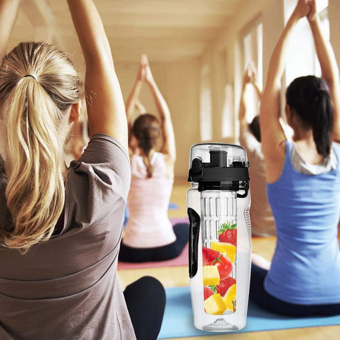 People exercising in a gym with a water bottle featuring fruit illustrations in the foreground.
