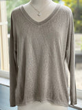 A lightweight taupe-colored sweater with silver trim on the neckline and bottom hem, displayed on a mannequin.