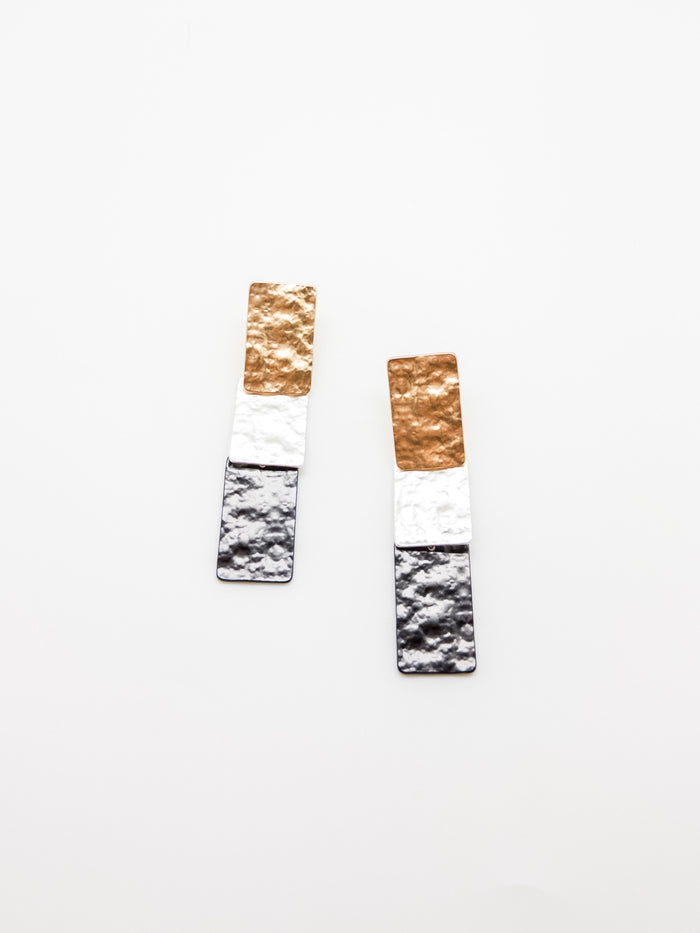 A pair of rectangular earrings with hammered metallic panels in gold and silver colors, lightweight and nickel-free.