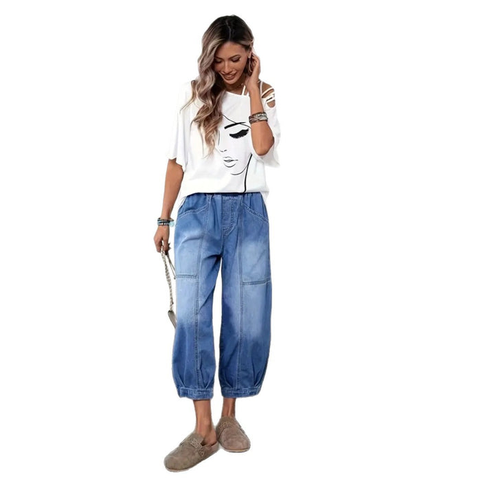 Full model view of blue cropped denim pants with elastic high waist, patch pockets, wide barrel legs, plus tan slip-on shoes.