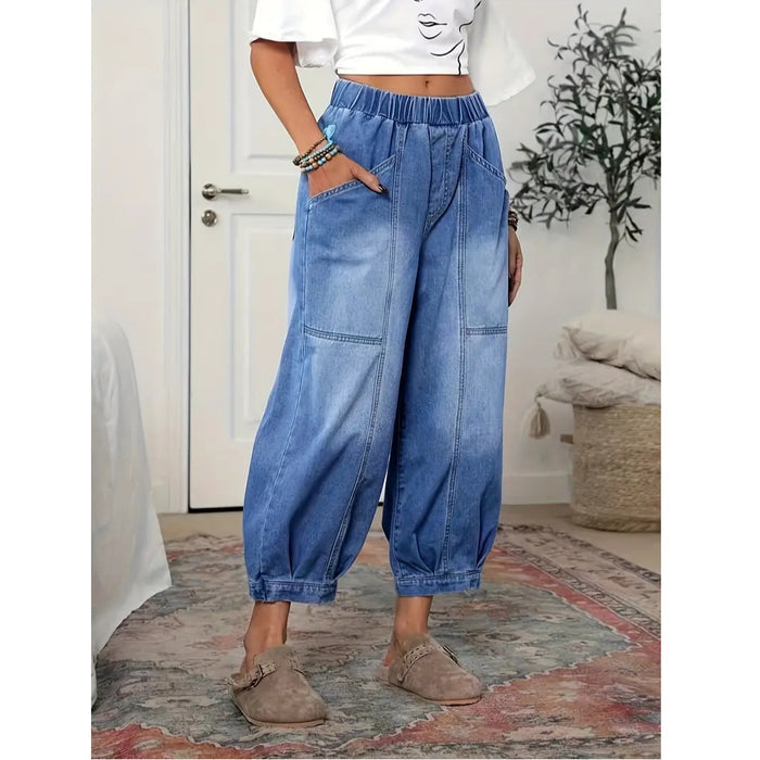 Front view of blue wide leg denim capri pants with elastic waistband, patch pockets, seam details, and cropped gathered hems.