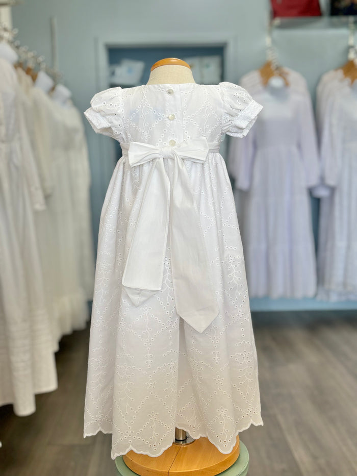 Back of white baby gown with buttons and tie bow.