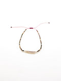 A purple bracelet with a baroque-style pearl and earthy-toned beads, featuring a sliding knot closure.