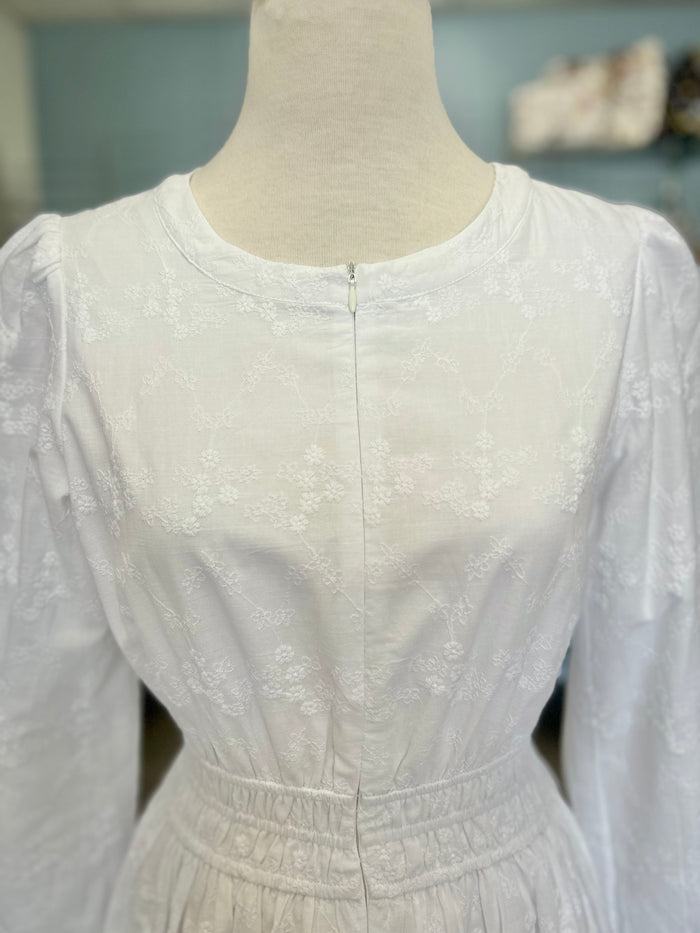 White zip front dress with embroidered design.