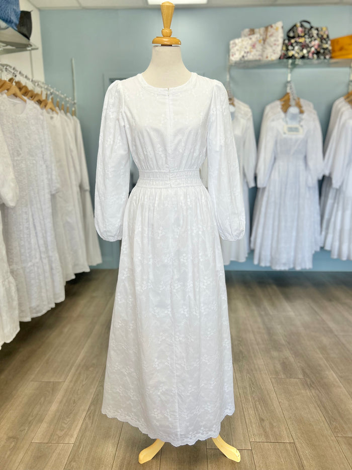 White cotton zip front dress with scalloped hem.
