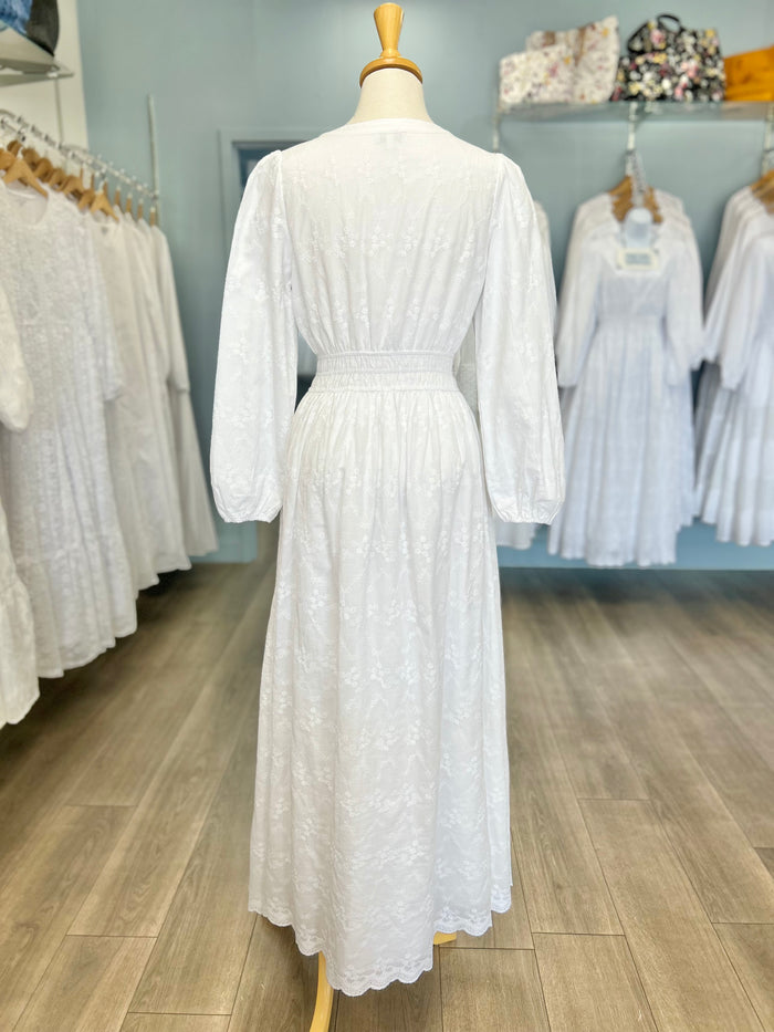 White cotton zip front dress with scalloped hem.