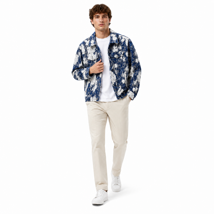 Man wearing a floral shirt over a white t-shirt with beige pants on a white background