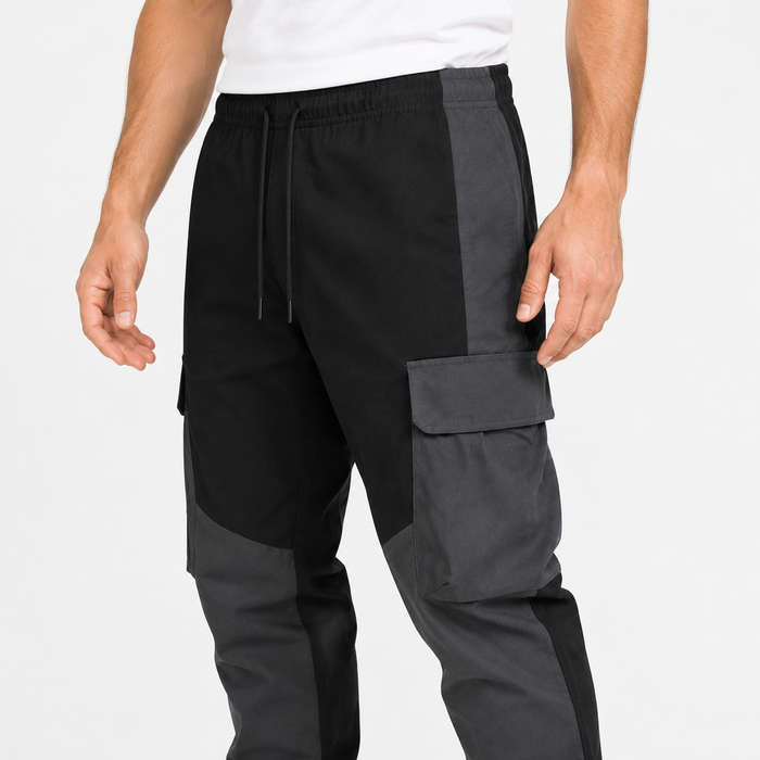 Close-up of men's black cargo trousers with drawstring waist, stitching and large flap pocket
