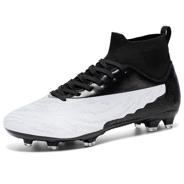 Top-down flat lay of outdoor football boots on green turf with ball partially in frame