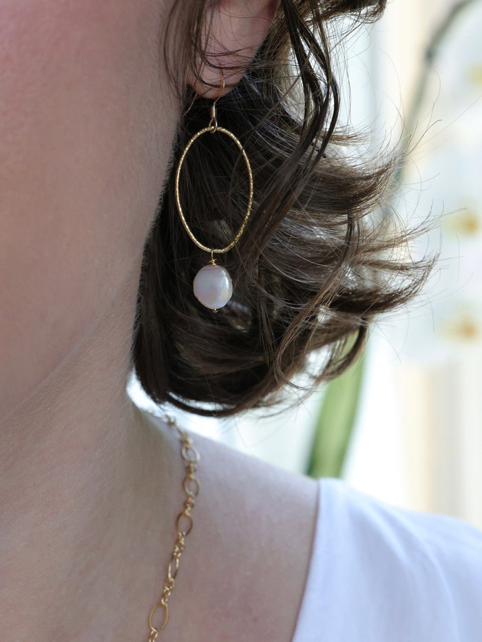 Model wearing Nina Hall gold oval earring with creamy white coin pearl from Ardor Boutique, handmade and nickel-free
