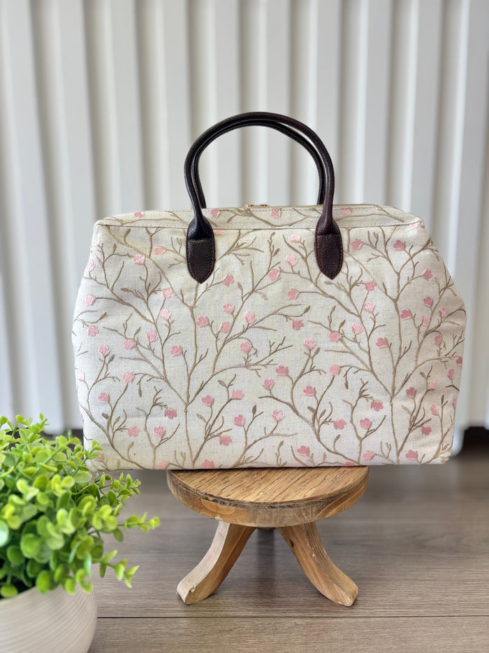 Beige zipper top bag with pink embroidered blossoms.