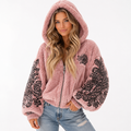 Winter travel outfit featuring a soft pink sherpa-style jacket and casual denim
