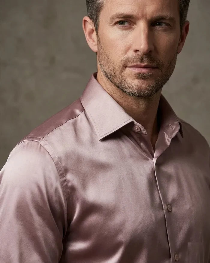 Man wearing a light pink dress shirt against a neutral background