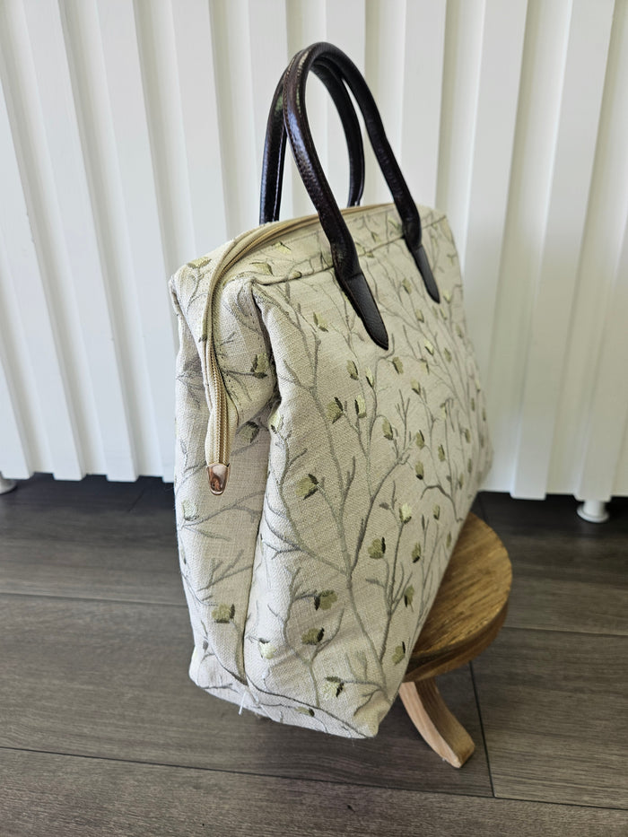 Beige zipper top purse with sage blossom design.