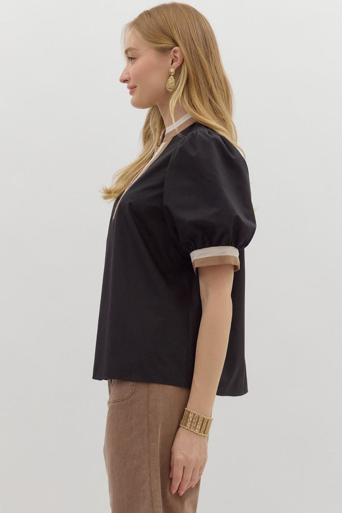 Women's black puff sleeve top with tan and cream trim by Entro showing side view