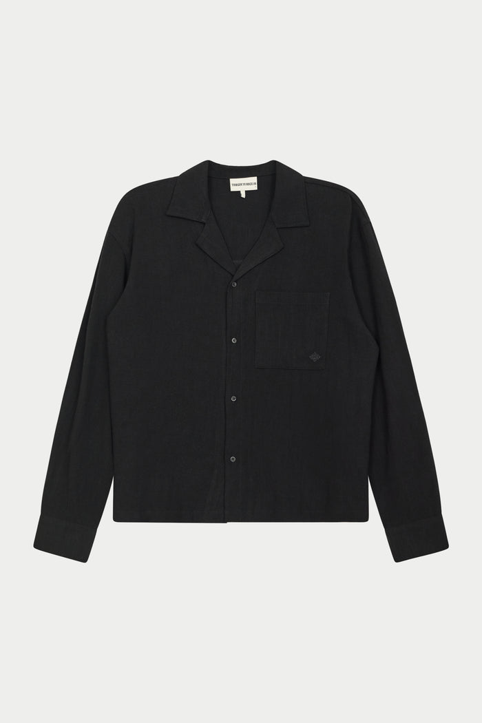 A long-sleeved black woven shirt with a revere collar, oversized chest pocket, and pearl branded button fastening.
