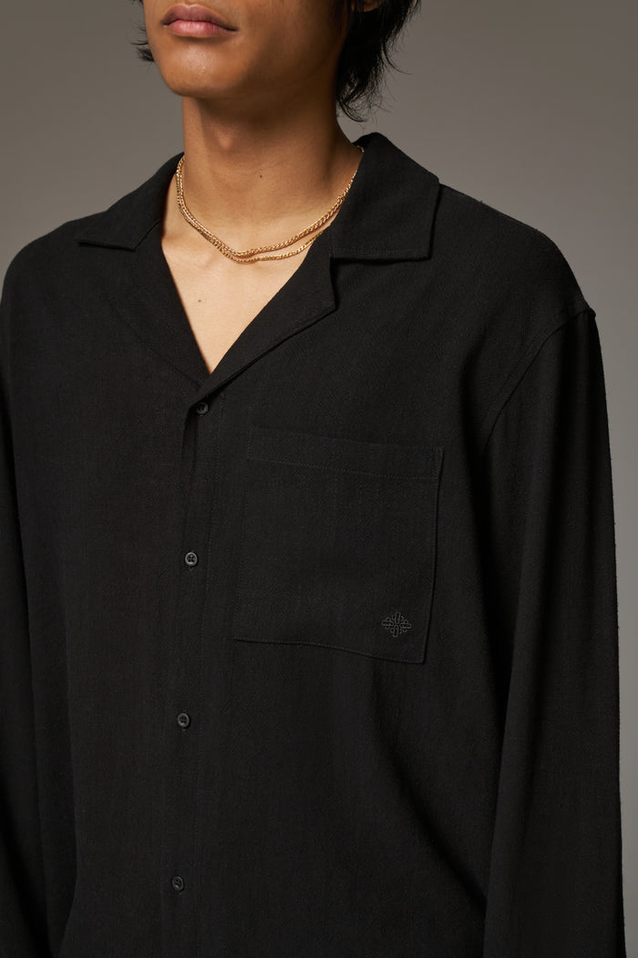 Close up detail shot of a man wearing a black long sleeved shirt