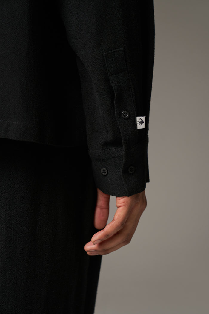 Close up detail shot of a black cuff on a neutral background
