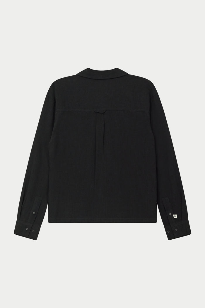 Back image of a long-sleeved black woven long sleeve shirt with a revere collar against a white background.
