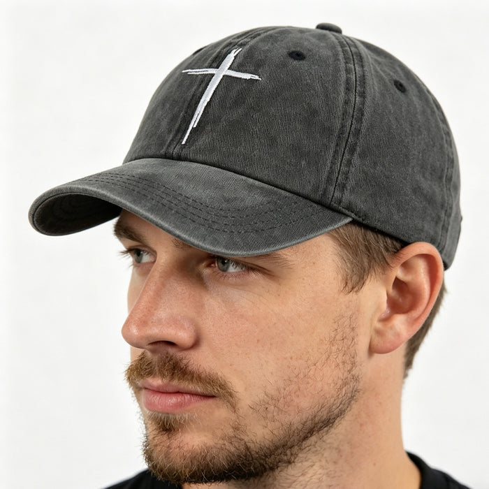 Man wearing a gray cap with a white cross emblem on a white background