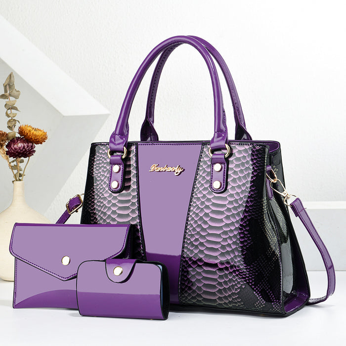 Purple handbag with snake skin pattern and matching wallet on a white background