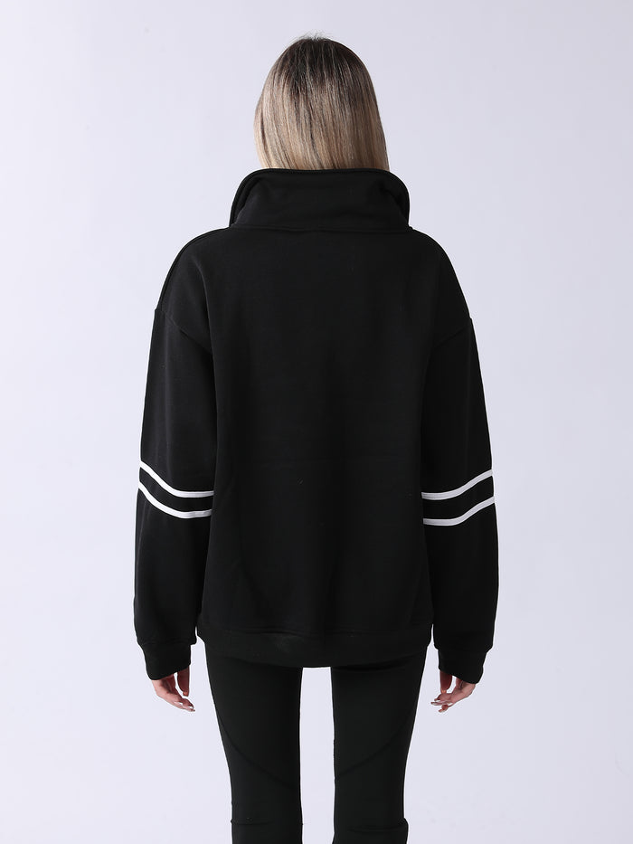 Person wearing a black hoodie with white stripes on sleeves against a white background