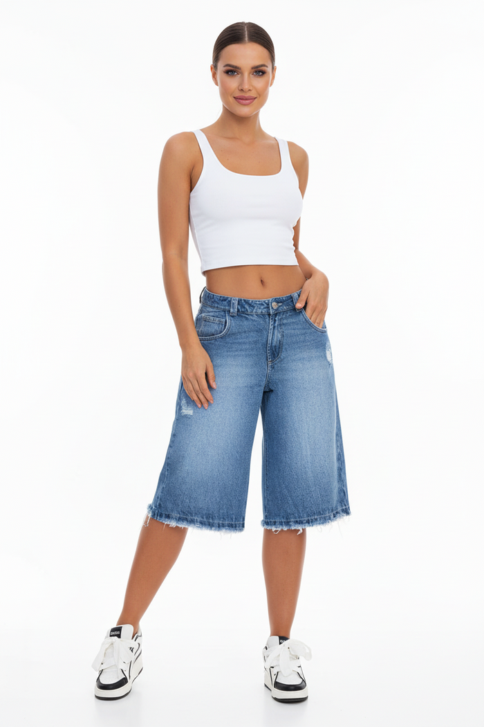 Front view of women's ripped denim shorts with raw hem and button detail