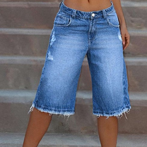 Angled shot of distressed denim shorts styled for a casual summer outfit