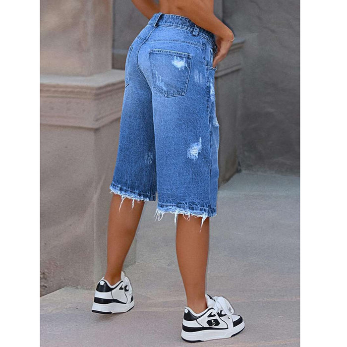Person wearing blue denim shorts with a blurred background