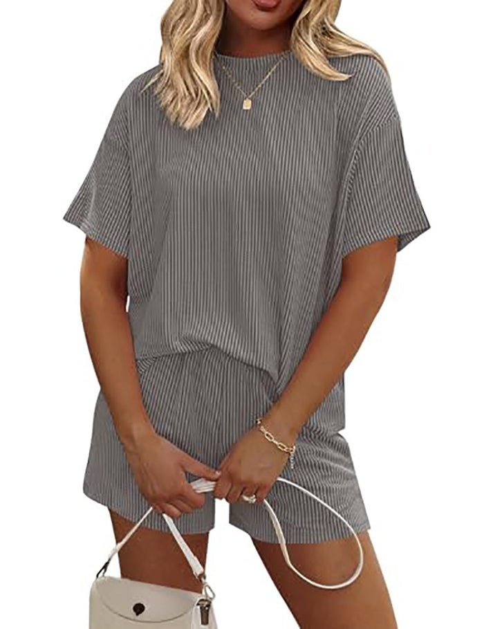 Woman wearing a gray striped outfit with a white background
