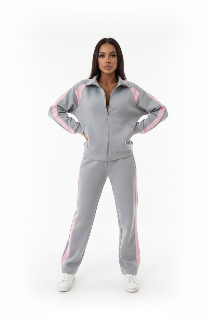 Model wearing pink zip-up tracksuit set at a gym entrance, sporty casual style, confident pose